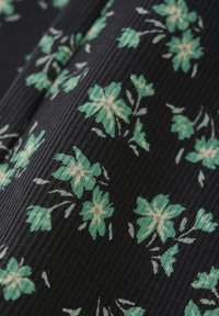 Geribbelde stof met groene bloemenpatronen op een marineblauwe achtergrond; bevat lichtbeige accenten op de bloemen en stelen.