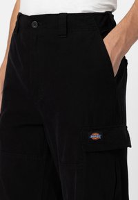 Czarne spodnie cargo wykonane z bawełny, z zapięciem na guzik, z bocznymi kieszeniami oraz naszywką z logo "Dickies" na udzie.