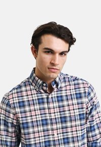 Hemd mit Knopfleiste in einem blau, pink und schwarz karierten Muster. Aus Baumwolle gefertigt, mit einem strukturierten Kragen und einer Brusttasche.