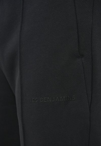 Black sweatpants made of soft fabric, featuring a slim fit and a subtle embossed logo "LES BENJAMINS" on the left side.