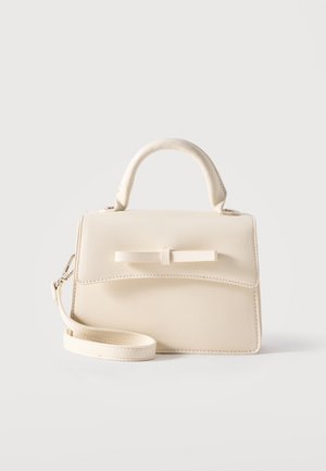 Piccola borsa beige con manico superiore, tracolla staccabile, patta frontale e fiocco orizzontale decorativo, su sfondo semplice.