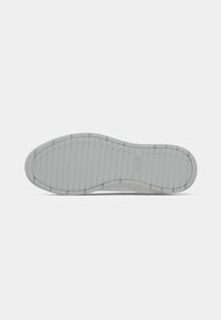Grey shoe sole with horizontal grooves and "BOSS" logo embossed near the heel, displayed on a white background.