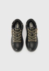 Sorte lærersneakers med gullfarge øyelets og vevde snorer, med rund tå og teksturert gummisåle. Logo på tungen.
