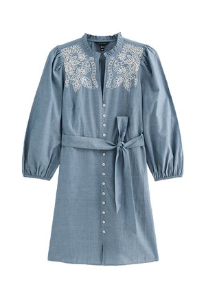 Lichtblauwe jurk tot over de knie met witte bloemrijke borduursels op de schouders, lange pofmouwen, knopen aan de voorkant en een taillestrikceintuur.
