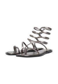 Graue metallische flache Sandalen mit einem spiralförmigen Knöchelriemendesign, dünnen Riemen und einer glatten strukturierten Sohle.