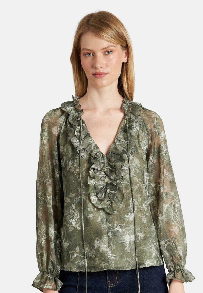 Durchsichtige grüne Bluse mit Blumenmuster, Rüsche am Halsauschnitt und langen Ärmeln. Verfügt über Kordelzüge und geraffte Manschetten. Strukturierter Stoff.