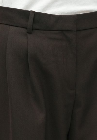 Tamno smeđi hlače s glatkom teksturom, koje imaju krojeni fit, prednje nabore i uski pojas za strukturiran izgled.