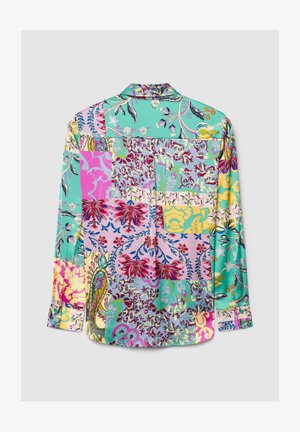 Chemisier multicolore pour femme présentant un design patchwork avec des motifs floraux et abstraits sur un fond turquoise, rose et jaune.