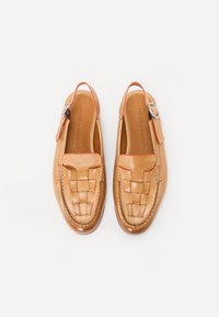 Tan läderslingbackskor med vävd ovandel, orange detaljer och en silverfärgad spänne. Slät textur och rund tåform.