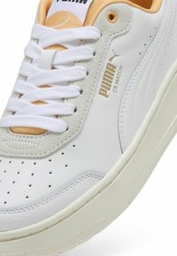 Sneaker Puma CA Match con tomaia in pelle bianca, dettagli in suede grigio, lacci abbinati e perforazioni sulla punta.