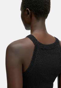 Schwarzes, gestricktes, ärmelloses Top mit rundem Halsausschnitt, strukturiertem Stoff und sichtbaren Schulternähten. Der Rücken ist glatt und figurbetont.