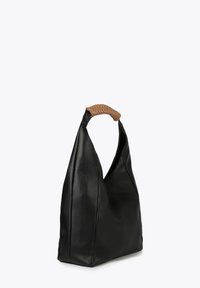 Sac en cuir noir avec une poignée tissée en tan, présentant un design décontracté et minimaliste ainsi qu'une base structurée.