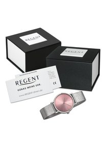 Montre en argent avec un cadran rose et un bracelet en maille texturée. Comprend des boîtes noires et blanches, ainsi qu'une carte détaillant les informations de garantie.