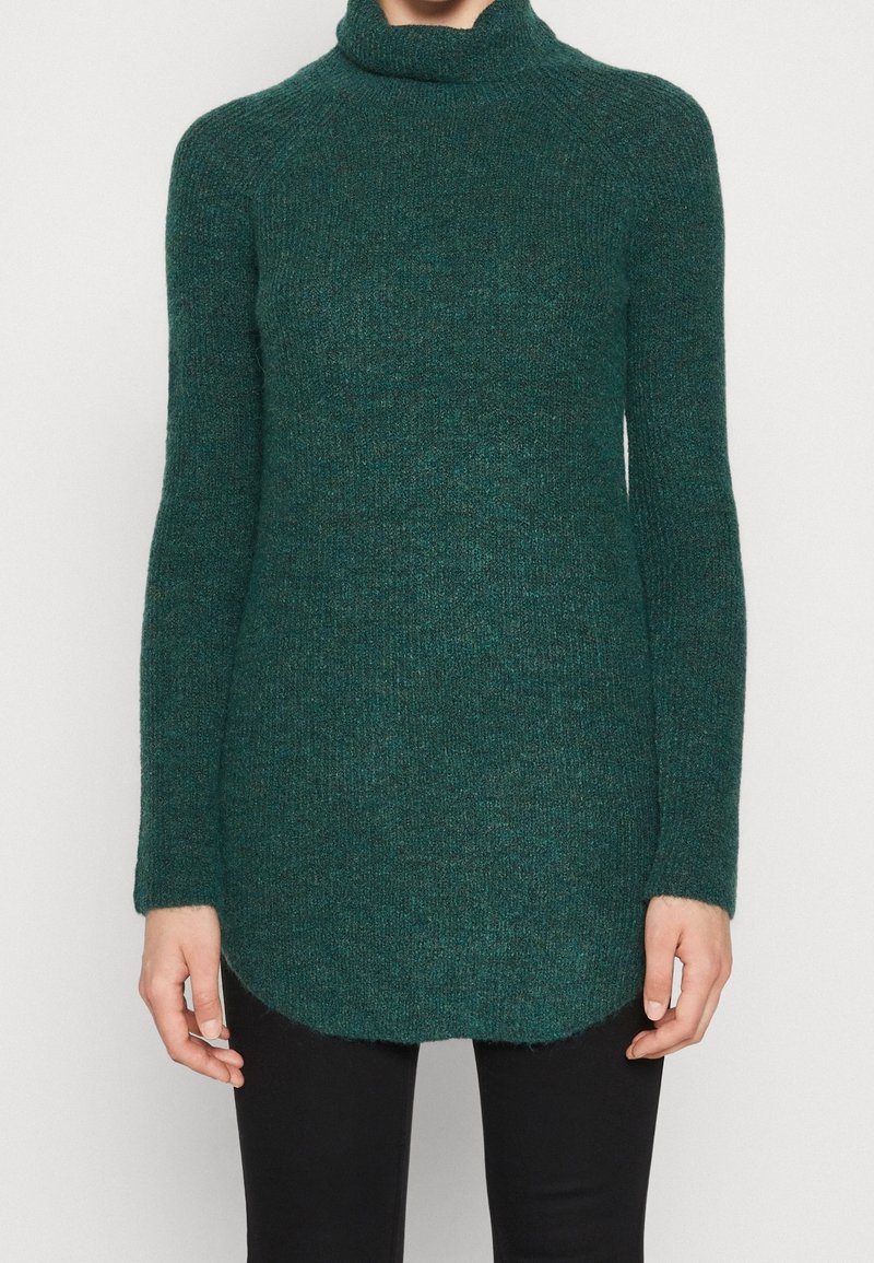 Sweter z golfem w ciemnym odcieniu teal, wykonany z teksturowanej dzianiny, posiada długie rękawy i zaokrąglony dół. Idealny do warstwowego noszenia.