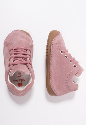 Rosa Wildlederschuhe mit runden Zehen und Schnürdesign. Die Gummisohlen haben strukturierte Muster. Innen ist ein Branding auf dem weißen Futter zu sehen.