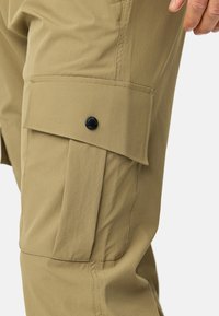 Beige cargobukser med en stor sidelomme, flad knaplukning og sømdetaljer. Fremstillet af letvægts, holdbart stof.