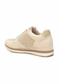 Zapatillas beige con un diseño floral recortado en los lados, textura suave y un respaldo texturizado con una suela ligeramente elevada.