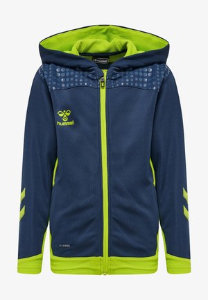 Sweat à capuche zippé bleu marine avec accents verts, présentant un design texturé, un motif à points sur les épaules, et un logo de marque sur le côté gauche de la poitrine.