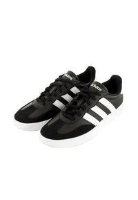 Chaussures de sport noires en matériau synthétique avec des accents de rayures blanches. Dotées d'un bout arrondi, d'une semelle en caoutchouc et d'un système de fermeture à lacets.