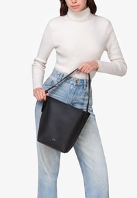 Borsa a secchiello nera in pelle con superficie texture, dotata di un manico corto e logo in rilievo sulla parte anteriore.