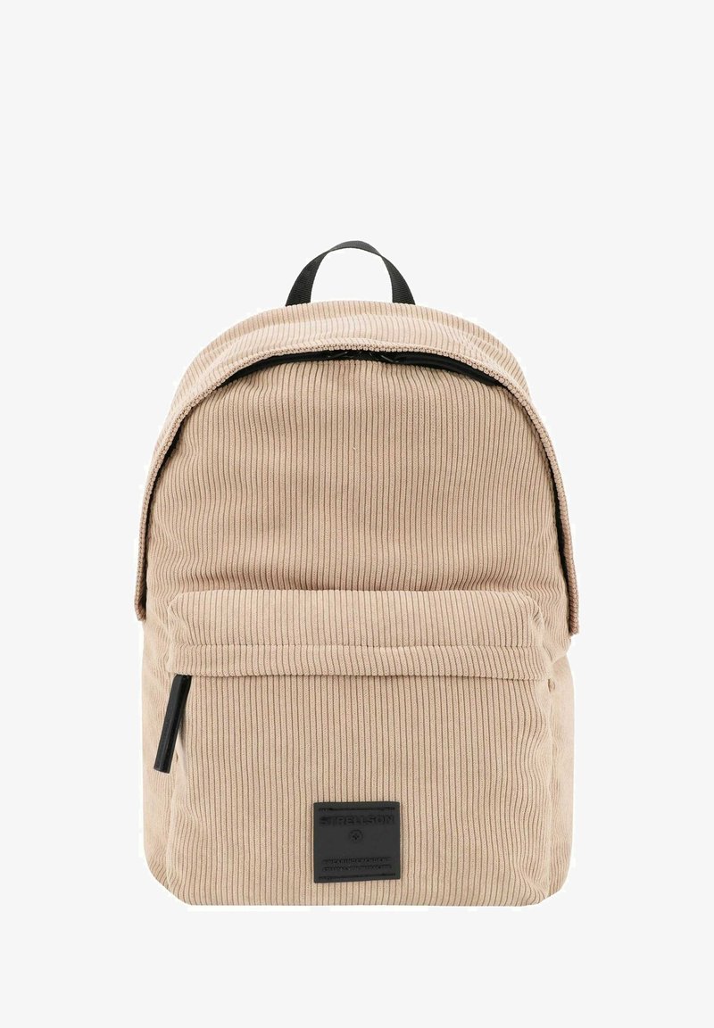 Beige korduroy batoh zaobleného tvaru s přední kapsou a černým zipem. Obsahuje horní ucho a čtvercovou značkovou nálepku.