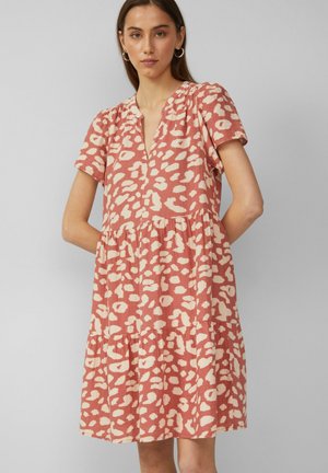 Pink and cream patterned dress with short sleeves, a v-neckline, and tiered skirt. Made from a textured fabric. Features side pockets.