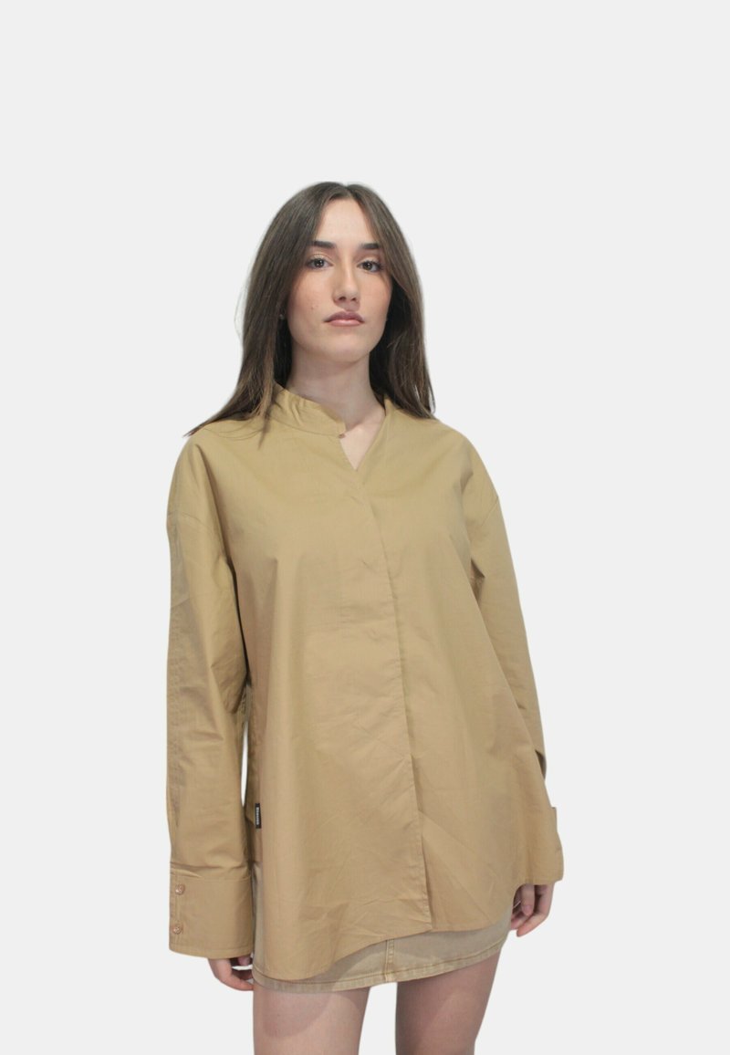 Camicia a maniche lunghe beige con colletto alla cinese, realizzata in tessuto leggero. Presenta polsini con bottone e una vestibilità rilassata con orlo curvo.