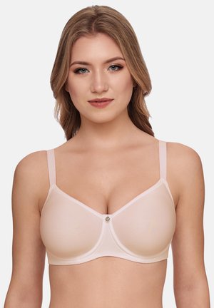 Woman wearing a nude, smooth-cup bra with thin adjustable straps and a small central decorative charm, facing forward against a plain background.