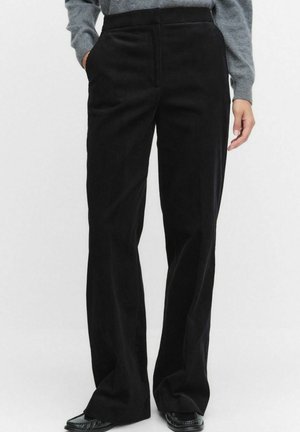 Zwarte corduroy wijde-pijp broek met een gestructureerd oppervlak, met zijzakken en een hoge tailleband, gestyled met een grijze gebreide top.