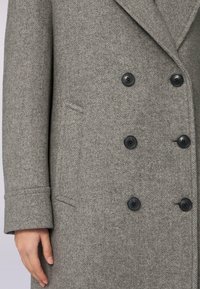 Cappotto in lana a spina di pesce grigio con design doppiopetto, bottoni neri e tasca laterale, tessuto testurizzato e revers a punta.