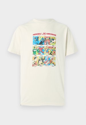 Light beige cotton t-shirt featuring a colorful comic panel print with various DC superheroes. Short sleeves and a crew neckline design.