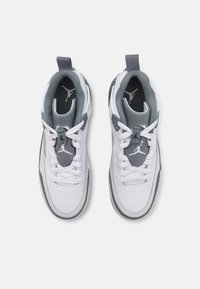 Des chaussures de sport blanches avec des accents gris, un design à lacets, une languette rembourrée et des semelles texturées. Comprend un logo au niveau du talon et de la languette.