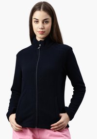 Giacca in pile blu navy con colletto alto, zip frontale e due tasche laterali. Presenta una superficie liscia e un design aderente per una vestibilità comoda.