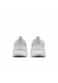 Scarpe da ginnastica bianche con una tomaia strutturata, dettagli perforati, soletta imbottita e un tassello sul tallone. Logo Nike sul lato.