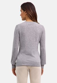 Grauer Strickpullover mit langen Ärmeln, rundem Ausschnitt und gerippten Bündchen. Weiche Textur, figurbetonte Silhouette und ein schlichtes Design.