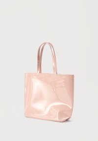 Λαμπερή ροζ τσάντα ώμου με διπλές λαβές, ορθογώνιο σχήμα και ανάγλυφο λογότυπο της μάρκας στο κάτω μέρος. Λείο υλικό, μινιμαλιστικός σχεδιασμός.