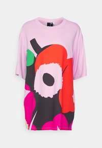 Camiseta oversize de algodón rosa claro con un gran diseño floral abstracto en rojo, verde, negro y rosa. Cuello redondo y mangas cortas.