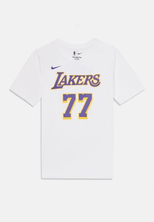 Valkoinen Nike T-paita, jossa etupuolella violetti ja kullanvärinen "Lakers"-teksti ja numero 77, NBA- ja Nike-logot kauluksen lähellä.
