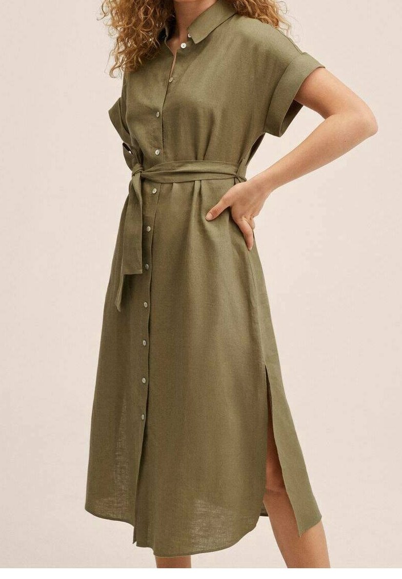 Olivengrøn skjortekjole lavet af let stof, med korte ærmer, knaplukning foran, bindebånd i taljen og sideslids for ekstra detaljer.