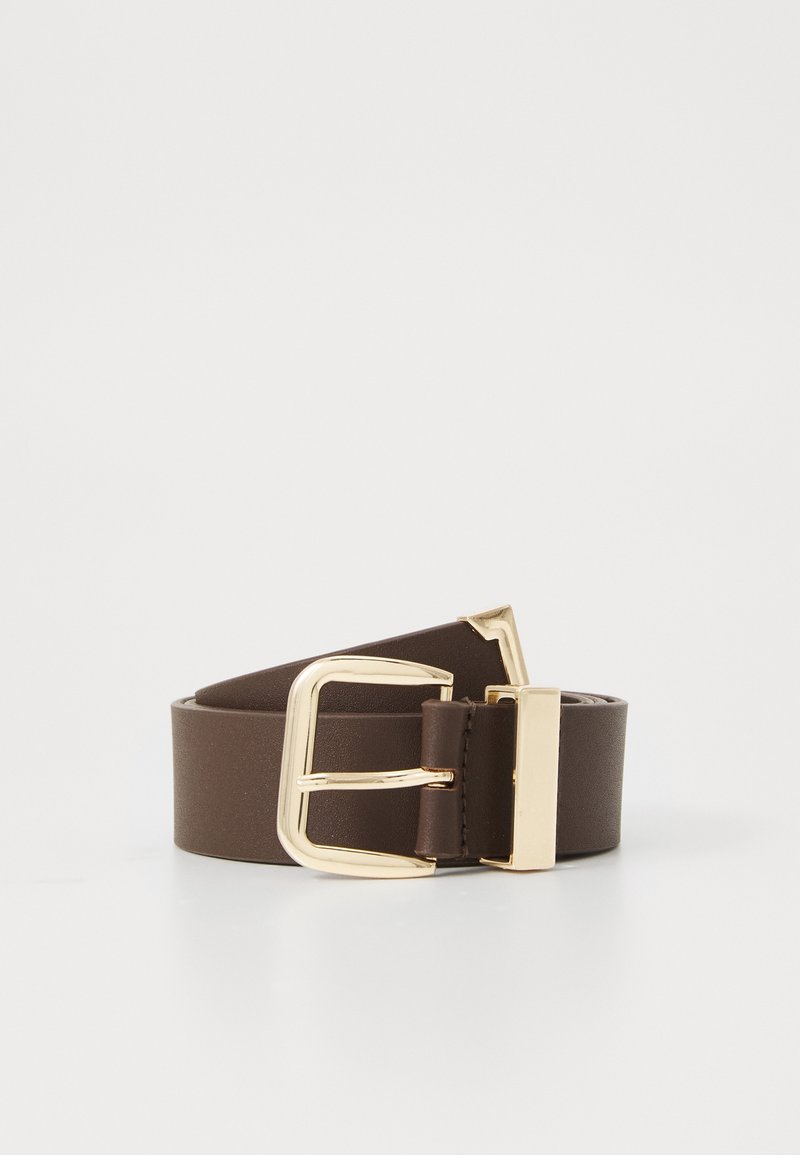 Ceinture en cuir marron foncé avec une boucle et une boucle en métal doré, roulée et posée sur une surface blanche.