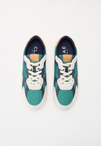 Sneakers verdi e blu marino realizzati in materiali a rete e camoscio, con lacci crema e dettagli color beige. Punta rotonda e suola in gomma.