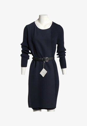 Marineblaues Strickkleid mit gerippten Ärmeln und seitlichem Einsatz, schwarzem Gürtel in der Taille, an einer Schaufensterpuppe mit weißem Etikett am Gürtel gezeigt.