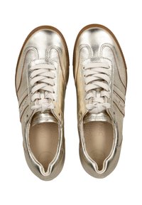 Metalliske gullsko med hvite snøringer, rund tå, beige fôr og en teksturert såle. Har brune detaljer langs sidene.