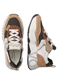 Zapatillas en materiales marrones, negros y blancos. Presentan texturas de ante y malla, suelas gruesas, patrones contrastantes y una marca prominente.