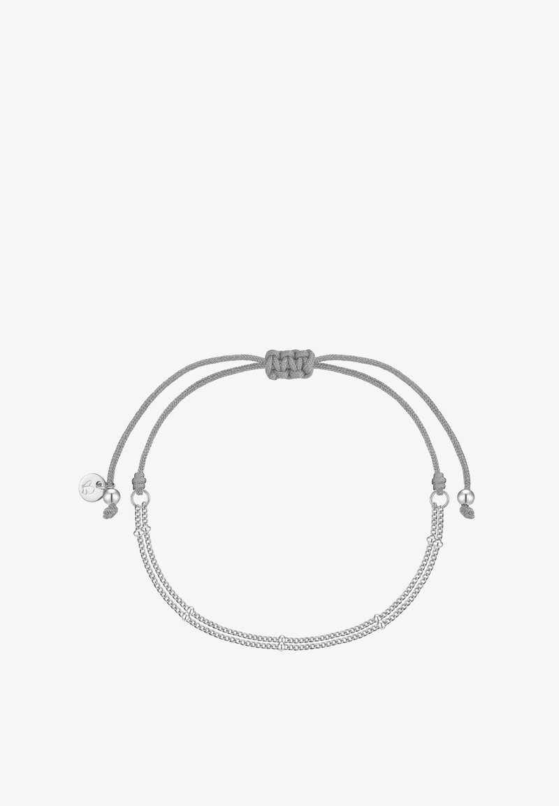 Pelēks austs aproce ar regulējamu aizdari, kas iekļauj divas plānas sudraba ķēdes un metāla akcentus. Tekstūru apdare uzlabo vizuālo detaļu.