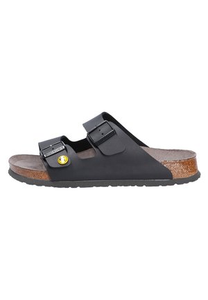 Black EVA slip-on sandal with two adjustable straps, cork footbed, and rubber sole, featuring a yellow logo detail on the buckle.