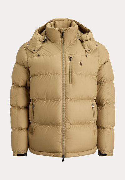 Beige padded winter jacket with high collar, front zipper, three zippered pockets, adjustable hood, and small logo on chest.