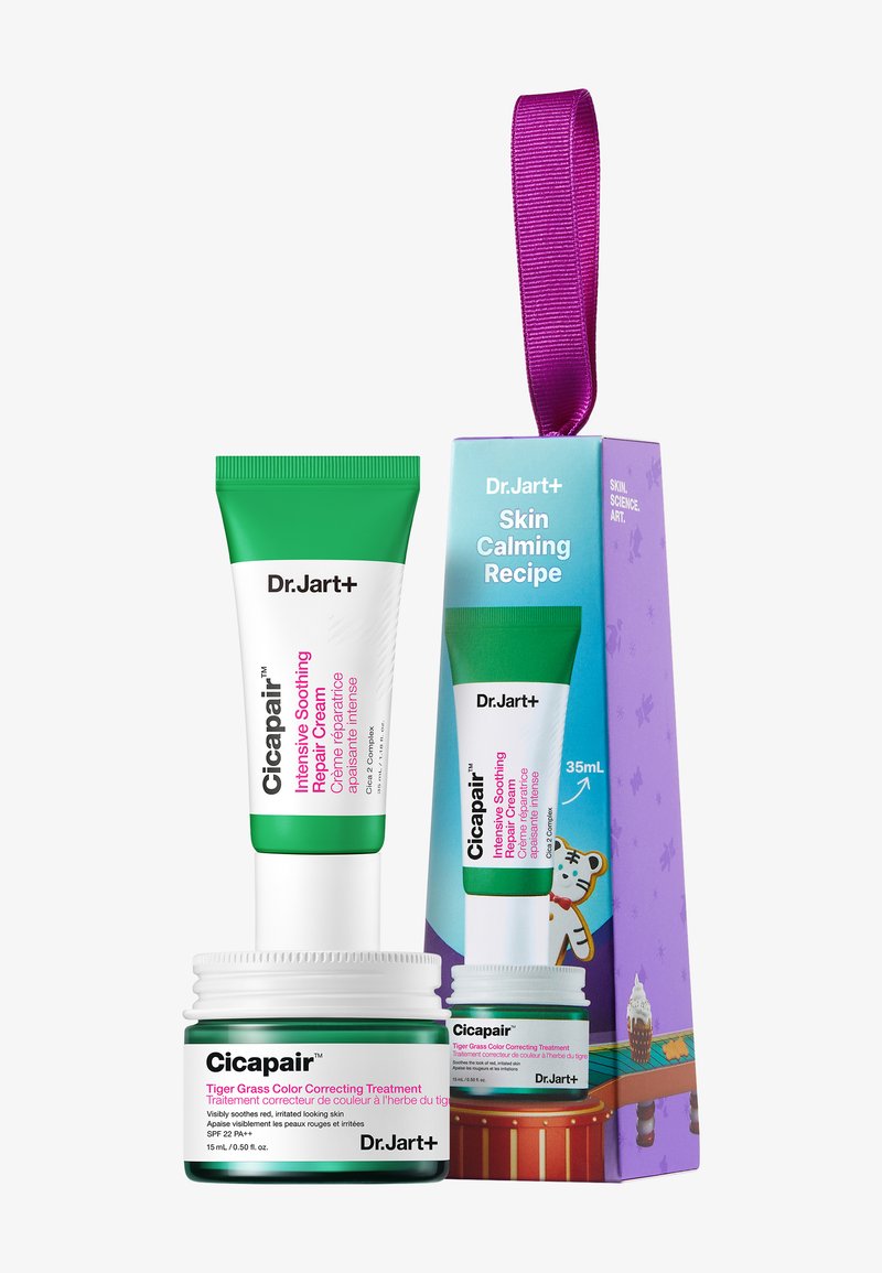 Dr. Jart+ Cicapair-settet inkluderer et grønt rør og et kremglass. Røret har en hvit base med grønne detaljer; glasset har et matchende design.