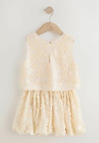 Creme kleurige pailletten jurk met een mouwloze top en een gerimpelde rok. Heeft een kleine knoopsluiting op de rug en een gladde textuur.