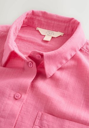 Rosa Leinenhemd mit Kragen und passenden rosa Knöpfen. Es besteht aus einem strukturierten Stoff und hat eine Brusttasche. Das Etikett weist darauf hin, dass es Leinen enthält.